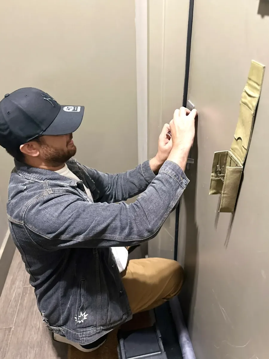 Ali, owner of Aura Locksmith, using lock picking tools on an apartment door during a Brooklyn lockout call