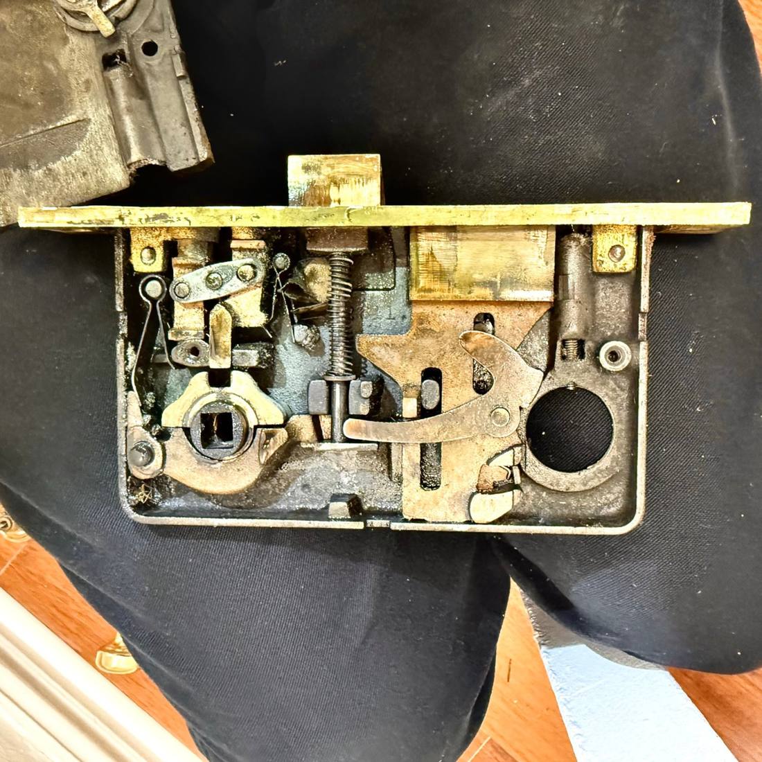 Disassembled brass mortise lock body on the workbench during a lock repair by Aura Locksmith in Brooklyn