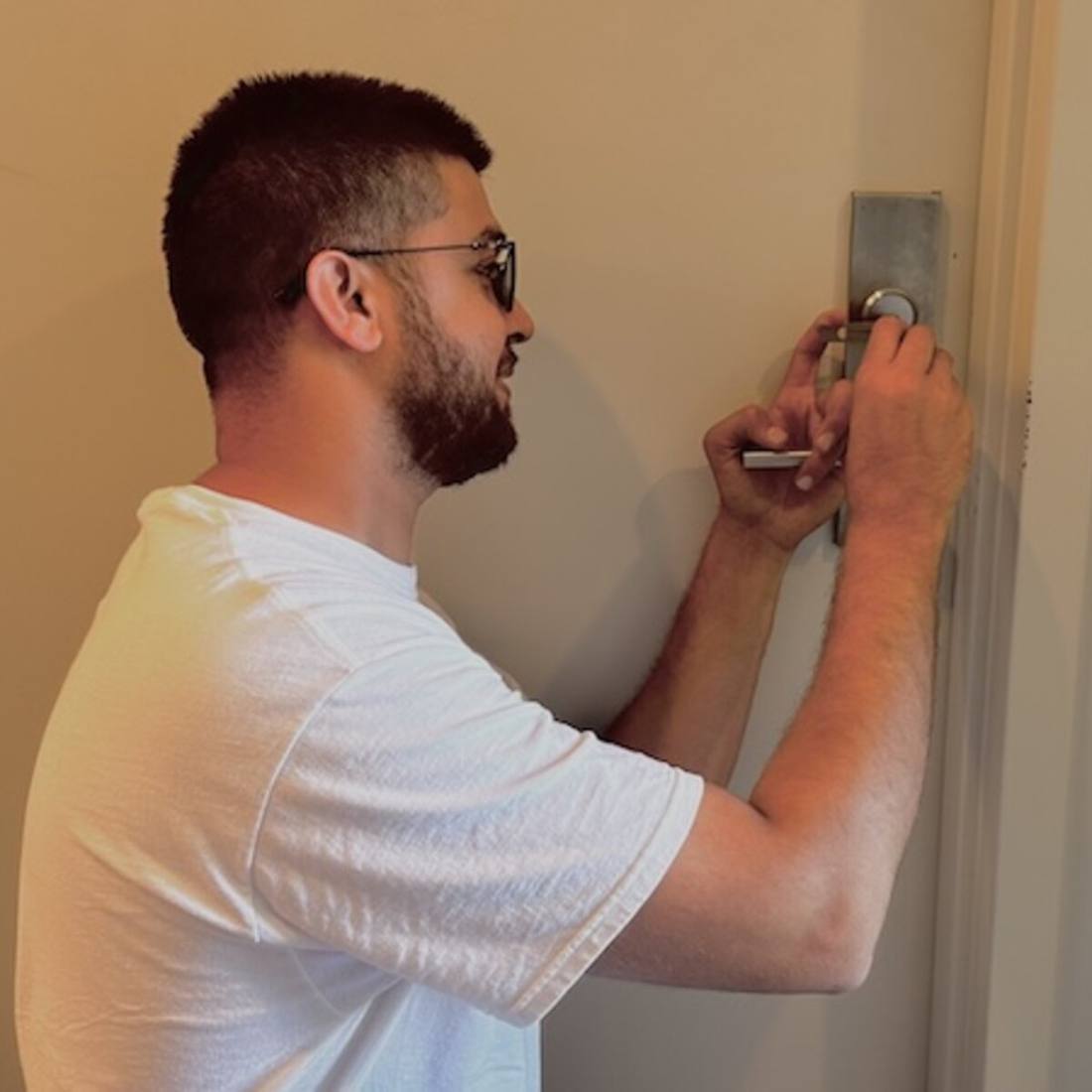 Ali, owner of Aura Locksmith, picking a lock on a Brooklyn apartment door during a lockout service call